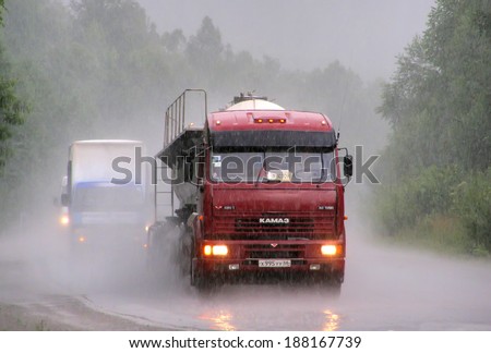 CHELYABINSK REGION, RUSSIA - JULY 22, 2007: Violet KAMAZ 6460 semi-trailer truck at the interurban road during a heavy rainstorm.