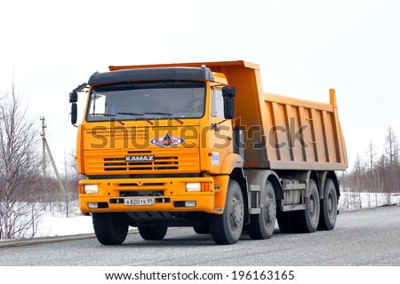 NOVYY URENGOY, RUSSIA - APRIL 23, 2013: Yellow KAMAZ 65201 dump truck at the interurban road.