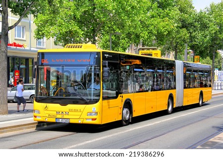 DRESDEN, GERMANY - JULY 20, 2014: Yellow articulated bus MAN A23 Lion\'s City GL at the city street.