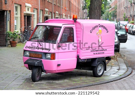AMSTERDAM, NETHERLANDS - AUGUST 10, 2014: Pink three-wheeled light commercial vehicle Piaggio Ape at the city street.