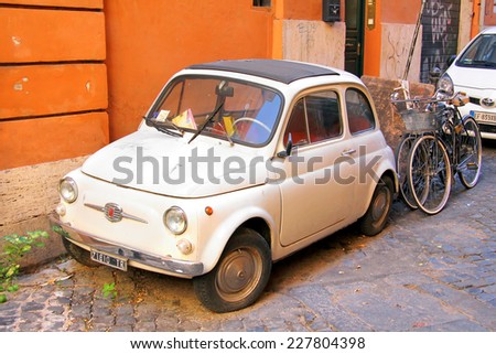 ROME, ITALY - AUGUST 1, 2014: White tiny retro car Fiat 500 at the old city street.
