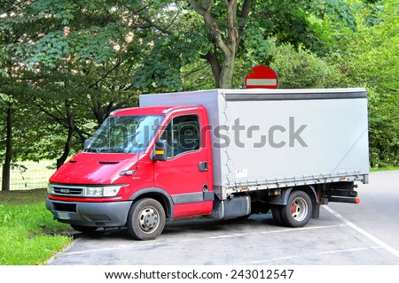VALAIS, SWITZERLAND - AUGUST 5, 2014: Red cargo truck Iveco Daily at the interurban road.