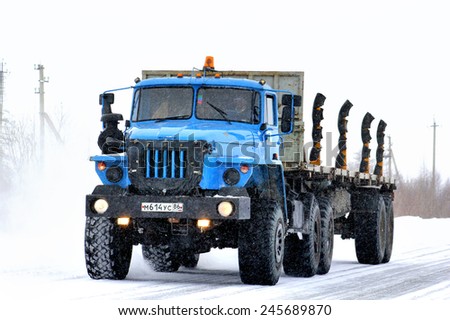 NOVYY URENGOY, RUSSIA - MARCH 31, 2013: Blue semi-trailer truck Ural 44202 at the city street during a heavy blizzard.