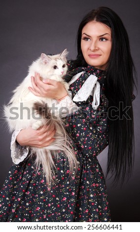 Young attractive woman with a cat over grey background