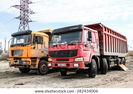 NOVYY URENGOY, RUSSIA - MAY 18, 2015: Abandoned chinese dump trucks at the city street.
