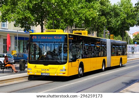 DRESDEN, GERMANY - JULY 20, 2014: Yellow articulated bus MAN A23 Lion\'s City GL at the city street.