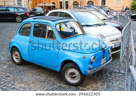 ROME, ITALY - JULY 31, 2014: Cyan tiny retro car Fiat 500 at the city street.