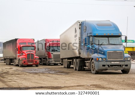 BASHKORTOSTAN, RUSSIA - MARCH 22, 2015: Semi-trailer trucks at the dusty parking near the interurban freeway.