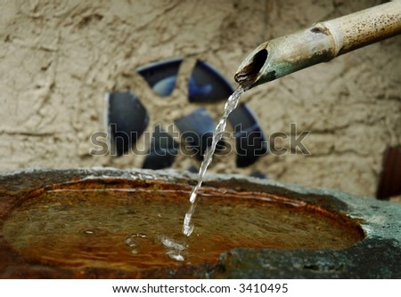 Bamboo fountain and stone bowl in Japanese garden