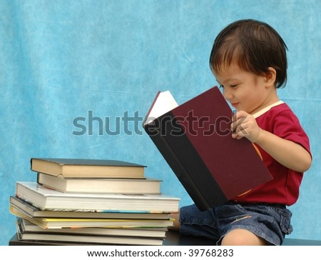 Two years old boy reading book
