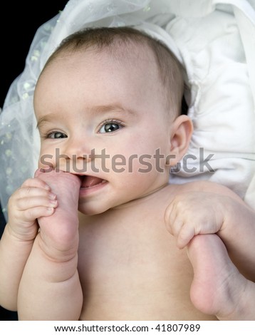 Baby with Foot in Mouth while holding other foot