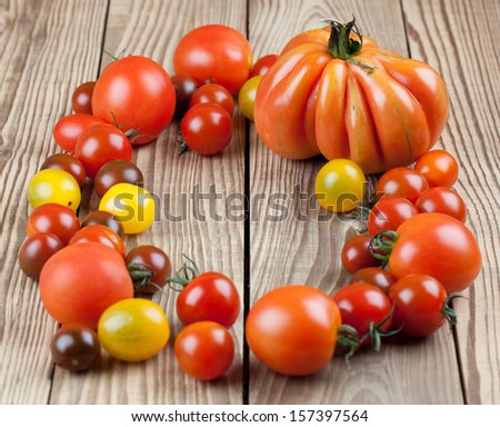 Yellow, red and black tomatoes on wooden background