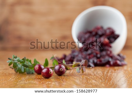 Fresh organic cranberries and a bowl with dried cranberries