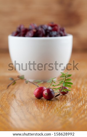 Fresh organic cranberries and a bowl with dried cranberries