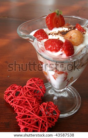 Yogurt dessert with fruits and little wicker hearts. Shallow DOF