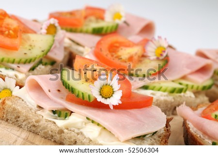 Spring sandwiches with ham, tomato, cucumber and cream cheese seasoned with freshly ground pepper