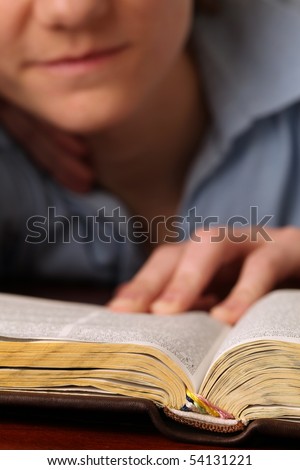 Young woman reading the Bible. Focus on the Bible
