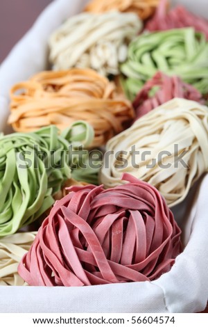 Assortment of colorful tagliatelle pasta dyed with natural dye from carrots, potatoes, spinach and beetroot