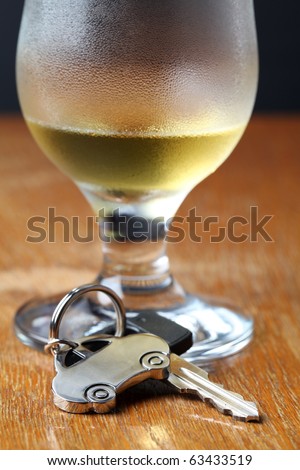Car key with car-shaped pendant and a glass of beer