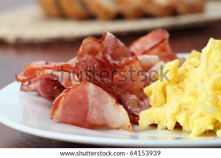 Scrambled eggs and slices of bacon on a plate