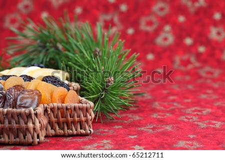 Christmas tree basket with dried fruits on red background. Shallow dof