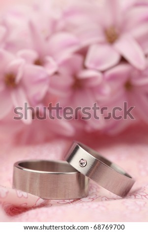 stock photo Titanium wedding rings on pink background with hyacinth