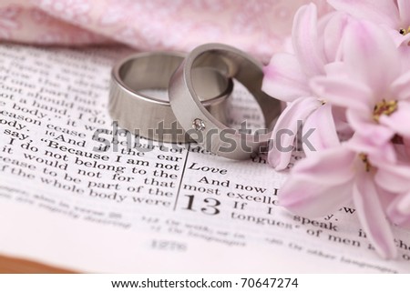 stock photo Titanium wedding rings on the Bible open to 1st Corinthians 13 