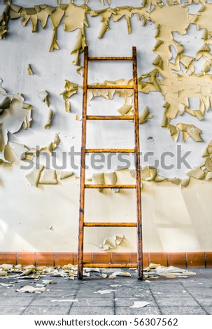Image of an old wooden ladder in an abandoned building with cracked and peeling paint illuminated by natural daylight and hard shadows.