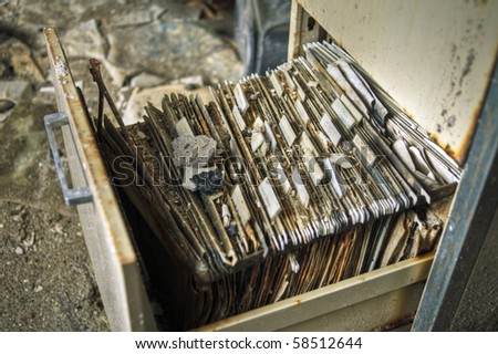 Image of an old rusty filing cabinet in a derelict abandoned police station covered in dust and debris.