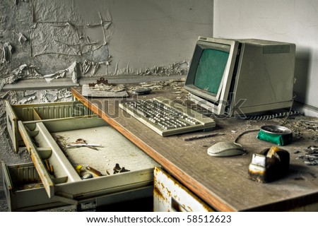 Image of an old, vintage computer in a derelict abandoned police station covered in debris and dust.