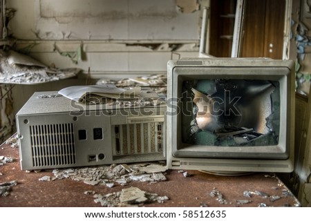 Image of an old, vintage destroyed computer in a derelict abandoned police station covered in debris and dust.