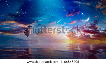 Amazing surreal background - crescent moon and hot air balloon rising above serene sea in sunset sky, glowing horizon and comet. Elements of this image furnished by NASA