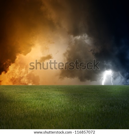 Nature force background - landscape with green field, dark sky and lightning