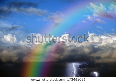 Rainbow in sky, dark and white clouds, lightnings in stormy sky