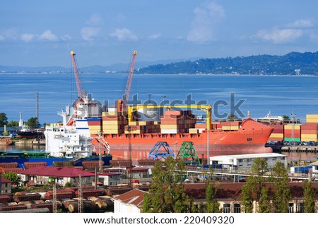 Transportation and logistic background - freight cargo ship and cranes in seaport