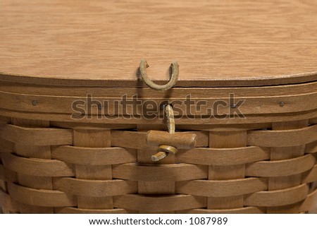 Lid of a woven basket - leather and wooden latch.