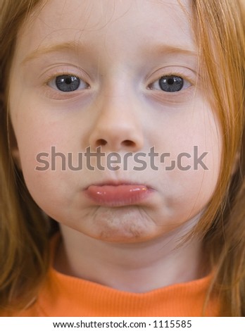 Red-Haired four-year-old girl with a pouting face.  Focus on eyes.