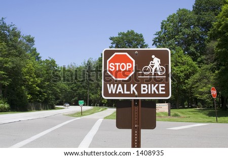 Stop and Walk Bike Sign posted in a public park. Not sharpened.