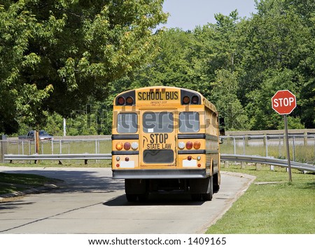 School Bus stopped at a neighborhood stop sign.
