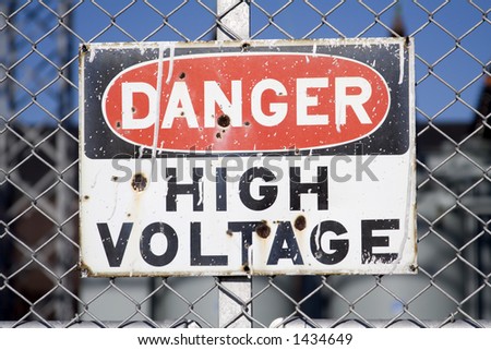 Grungy weathered danger high voltage sign warning posted on fence.  Not sharpened.