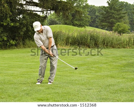 Lob wedge shot - Golf ball hovers above left pocket - grass flying above feet. Needs to be sharpened.