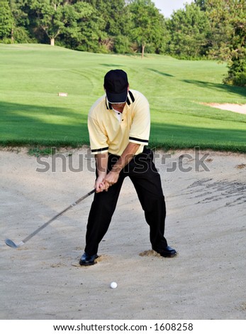 Man hitting ball out of sand trap - golfing.