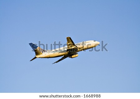 Continental commercial jet takes off into the early evening sky.