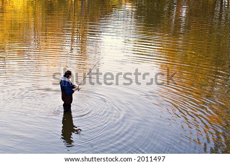 A Ohio man fishing in a creek in the fall - sunset is approaching.