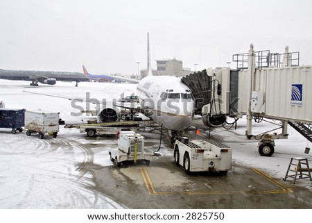 Commercial airlines preparing for departure during a snowy winter day in Cleveland Hopkins Airport.