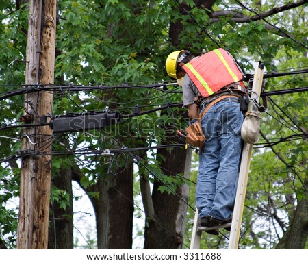 A man on ladder working on the power lines.