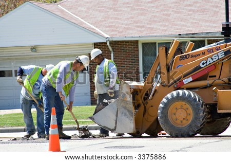 Water company workers repairing a problem in the middle of a busy street - Cleveland suburb.