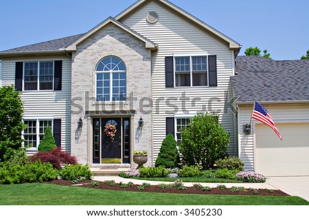 A beautiful neat suburban home in Ohio flying the American Flag.