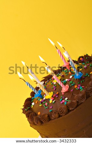 A diagonal shot of birthday or anniversary cake with lit candles.