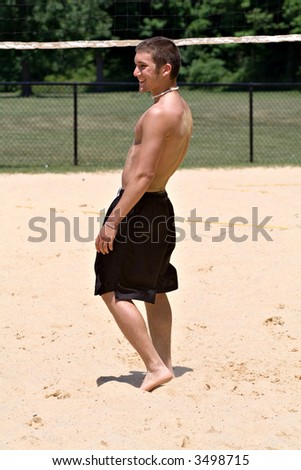 Young college age male playing volleyball on summer break.